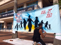 Completing his "Women's March" mural.